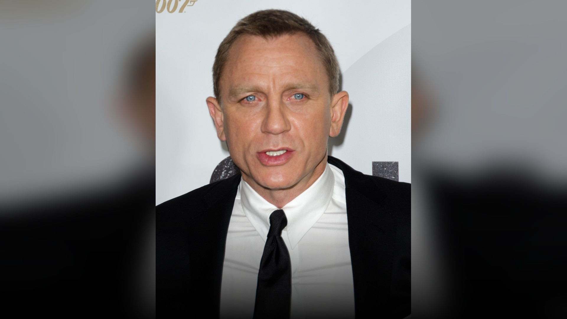 Daniel Craig on the red carpet in a tailored navy suit.