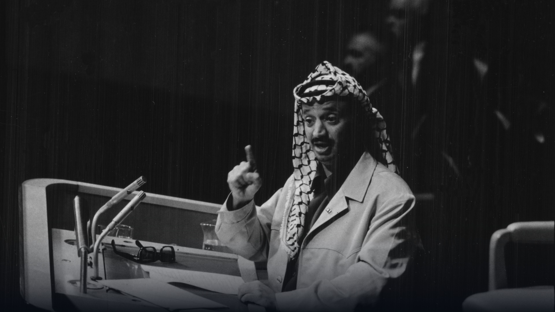 Historical portrait of PLO leader Yasser Arafat in signature keffiyeh.