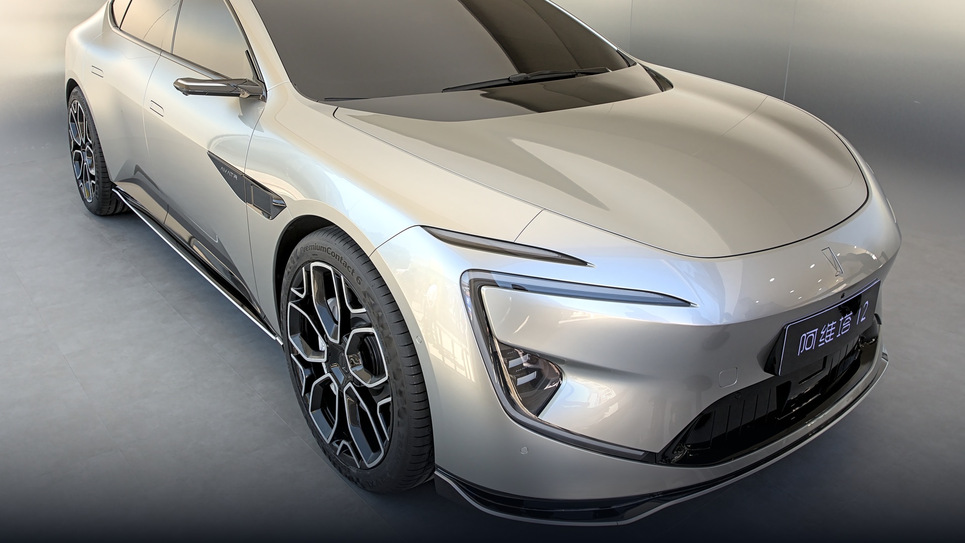 Sleek dark Avatr 12 Gran Coupe electric fastback on IAA Mobility auto show turntable.