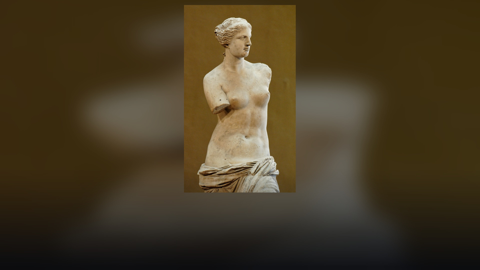 Ancient Greek marble statue of Venus de Milo on display at the Louvre Museum.