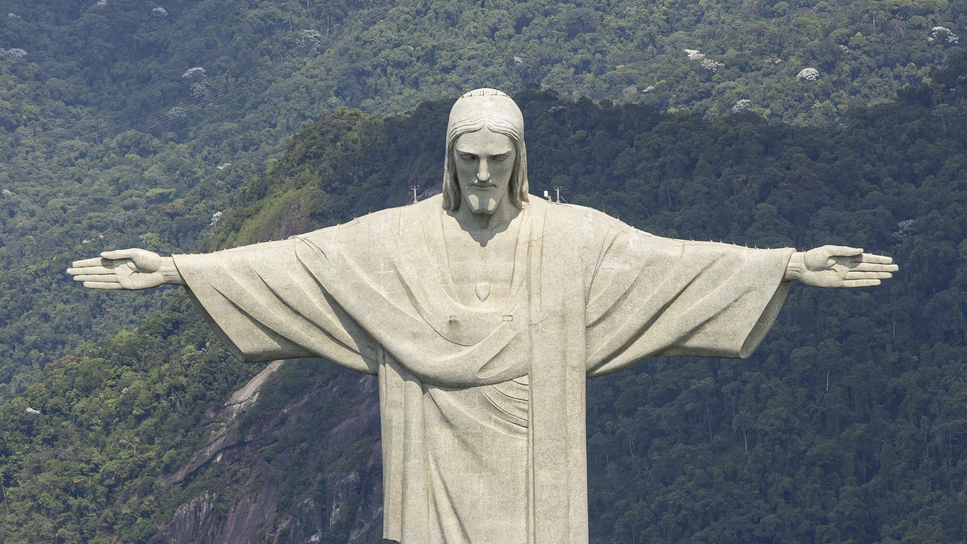 The majestic statue of Christ the Redeemer atop Corcovado mountain with arms outstretched overlooking Rio de Janeiro.
