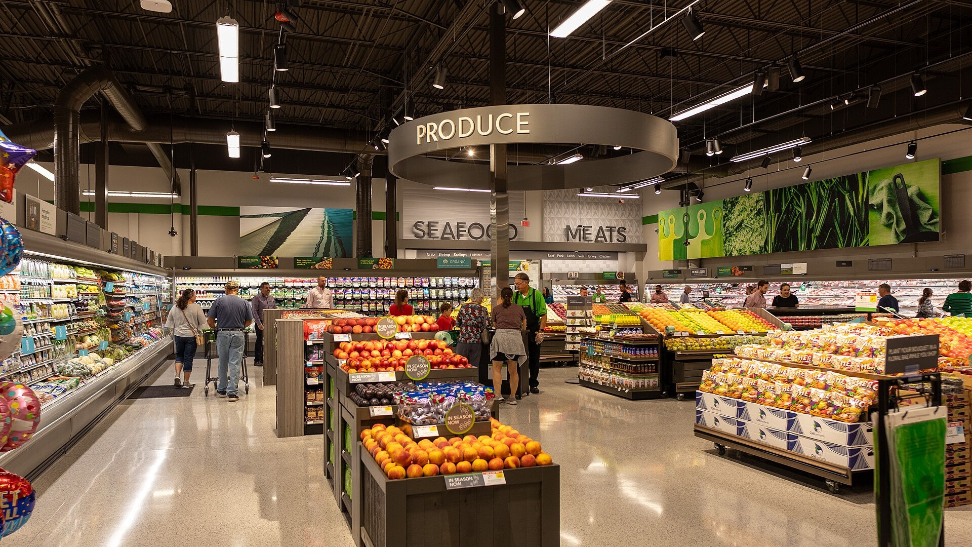 Supermarket produce section with fresh fruits and vegetables displayed.
