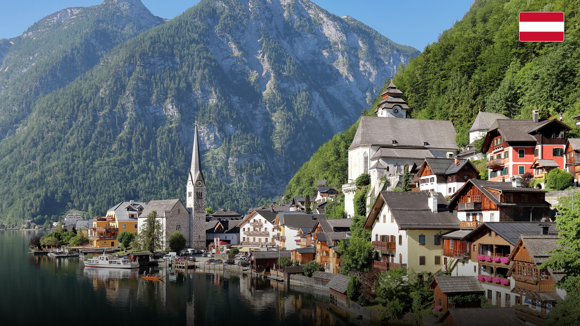 Lakeside alpine village of Hallstatt Austria with traditional timber houses reflecting in clear water.