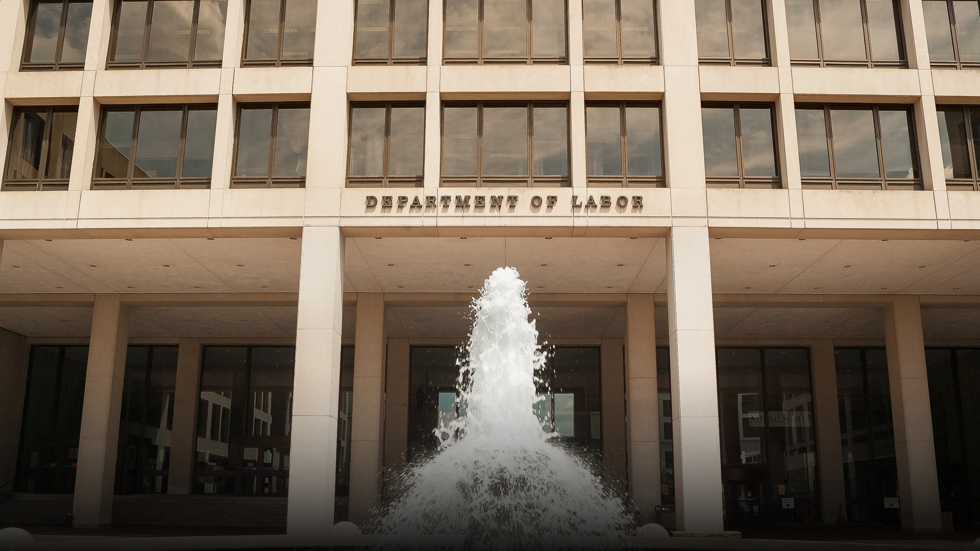 Front facade of the Frances Perkins Building, headquarters of the U.S. Department of Labor in Washington, D.C., with the Department of Labor inscription and plaza fountain.