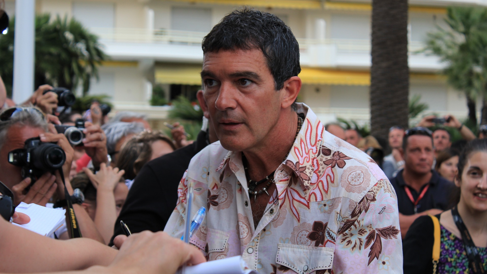 Spanish actor Antonio Banderas smiling warmly in a dark jacket.