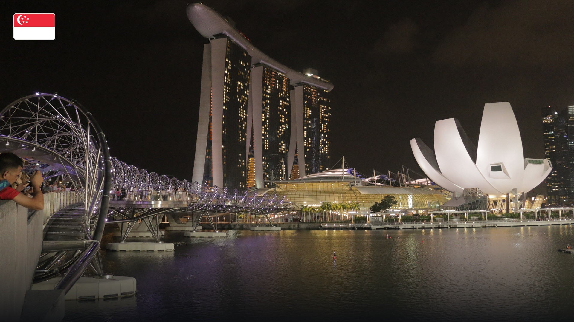 The futuristic towers and SkyPark of Marina Bay Sands in Singapore, with the flag of Singapore.