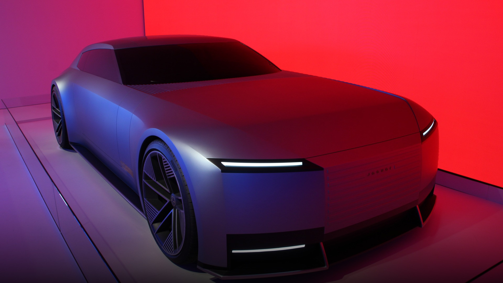 Sculpted bonnet and flush aerodynamic surface lines of the Jaguar Type 00 illuminated by studio light.