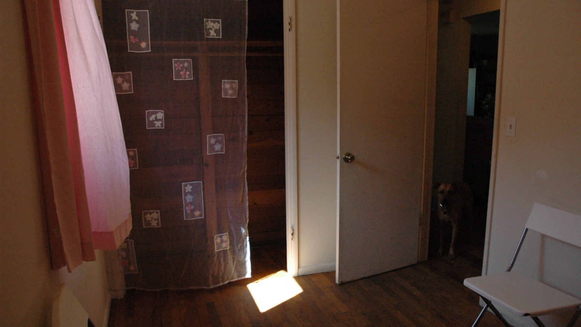Small bright room with pink curtains and natural window light