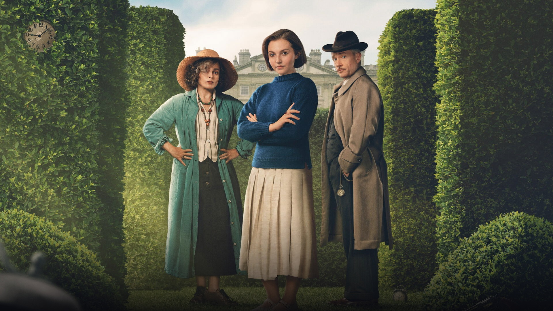 Mia McKenna-Bruce, Helena Bonham Carter, and Martin Freeman standing in a manicured English country estate maze.