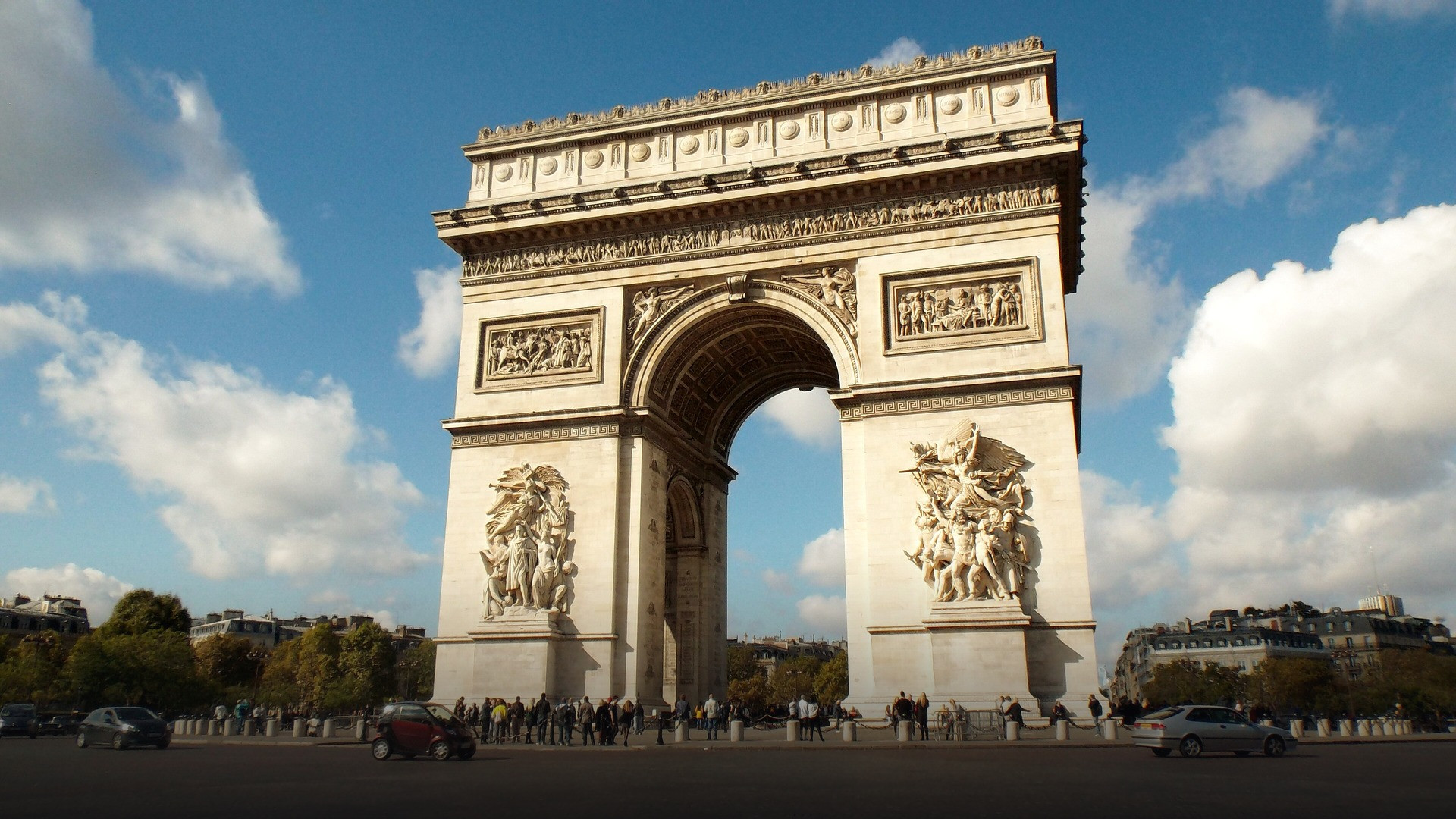 The complete Arc de Triomphe from pavement to attic standing majestically at the center of Place Charles de Gaulle.