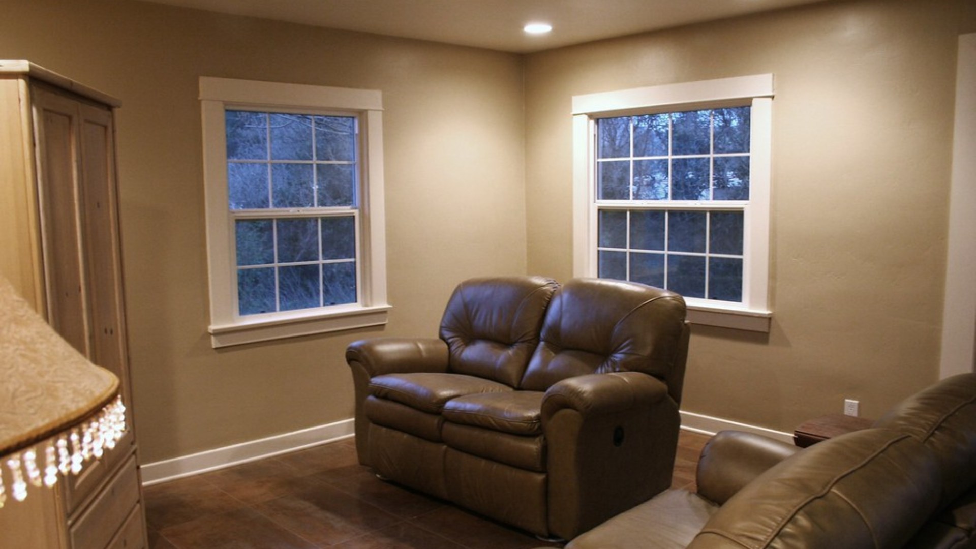 Warmly lit living room with sofa and armchairs arranged around a coffee table