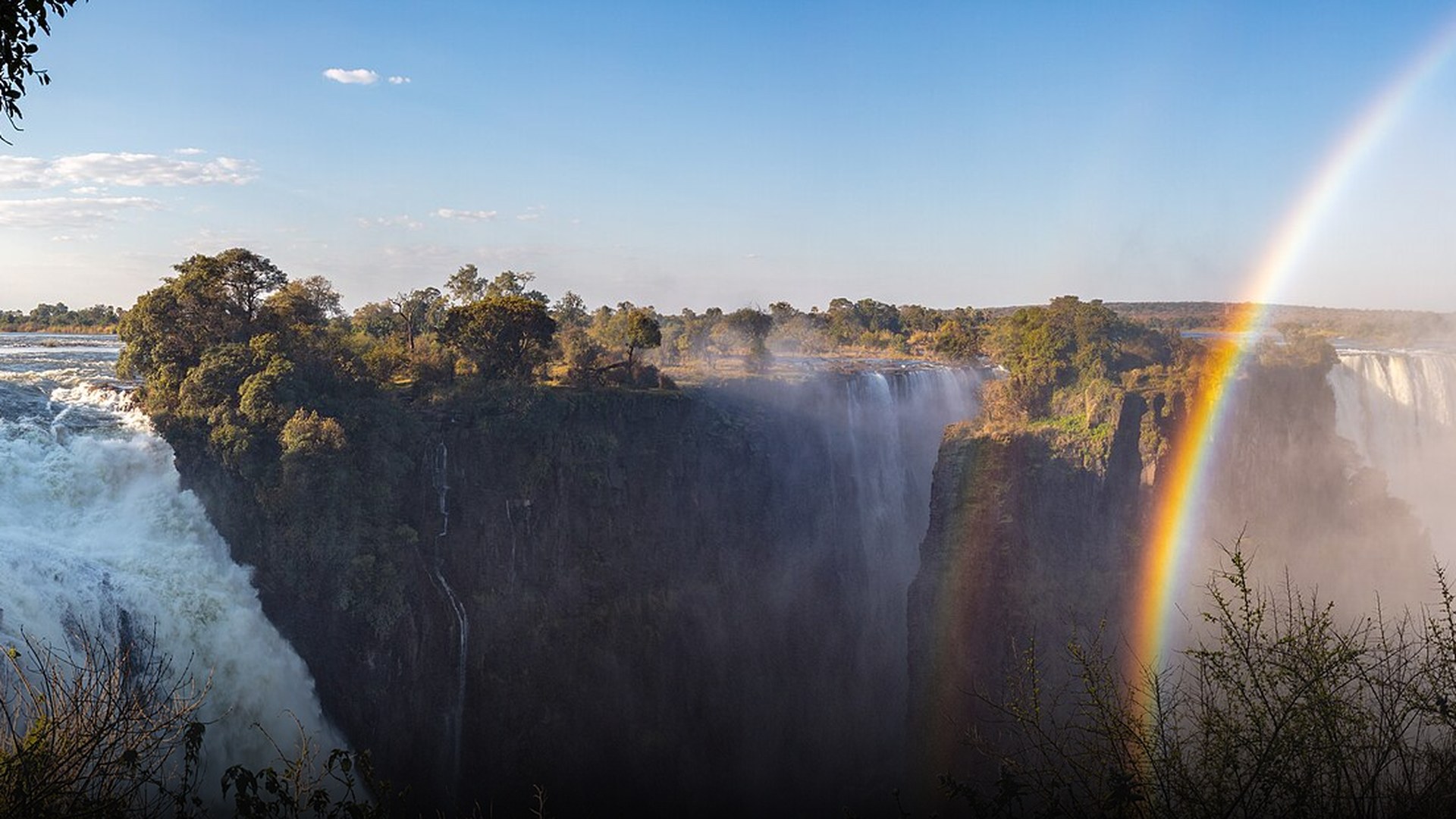 Massive misty curtain of water plummeting over Victoria Falls along the Zambezi River between Zambia and Zimbabwe.