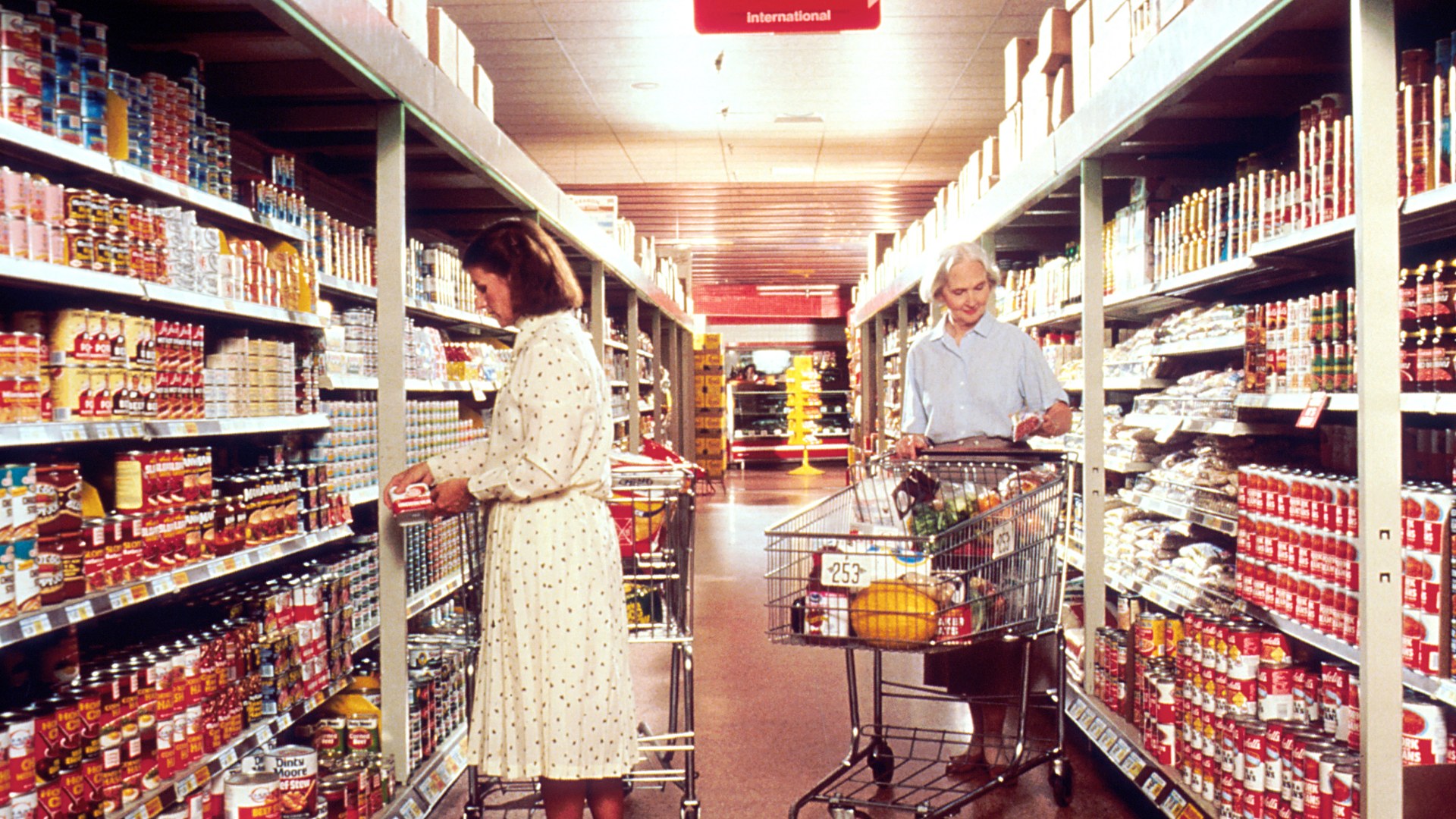 Shoppers browsing grocery items in a supermarket aisle
