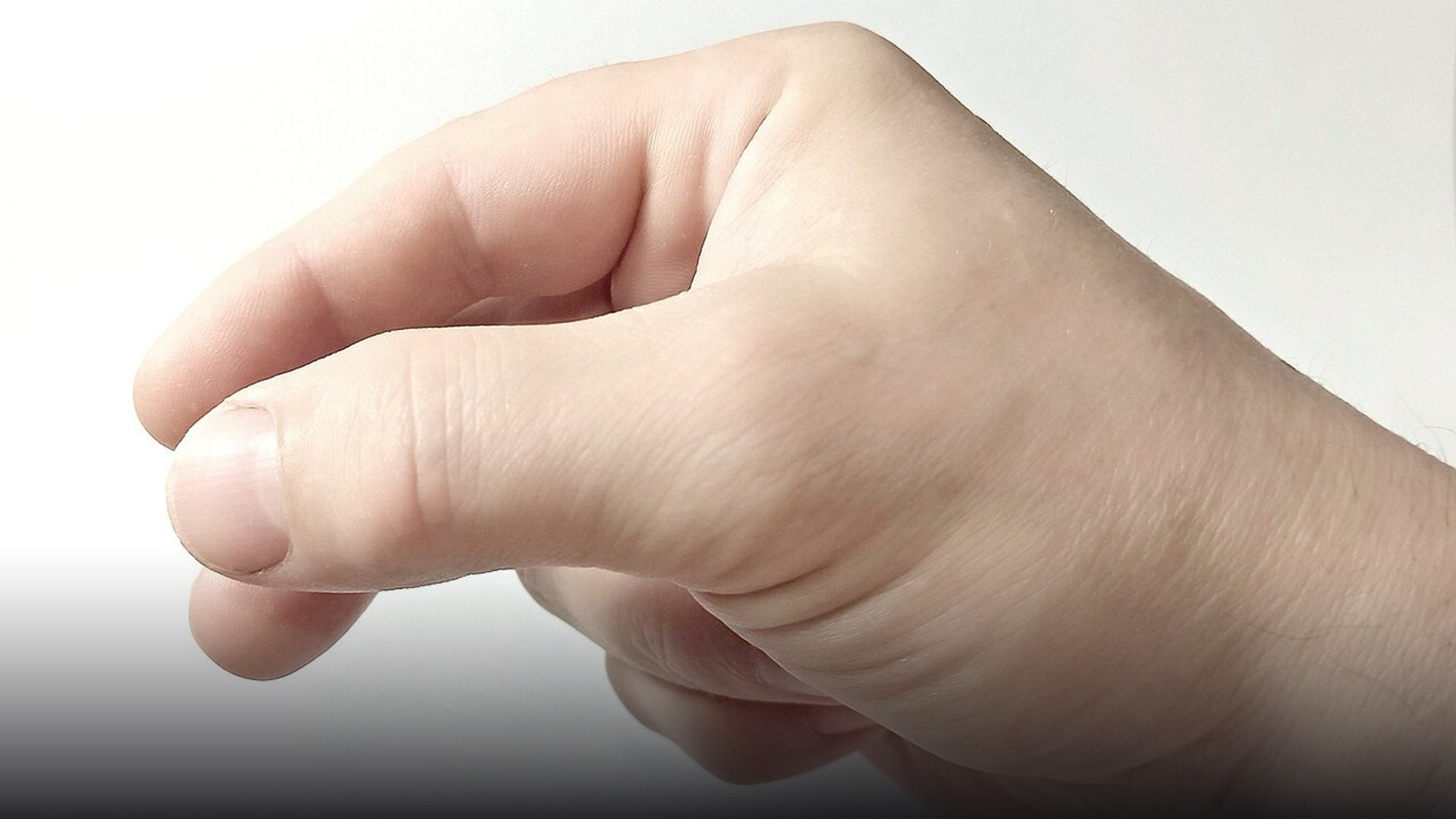 Human hand performing an exact micro-pinch gesture between index finger and thumb for spatial interaction.