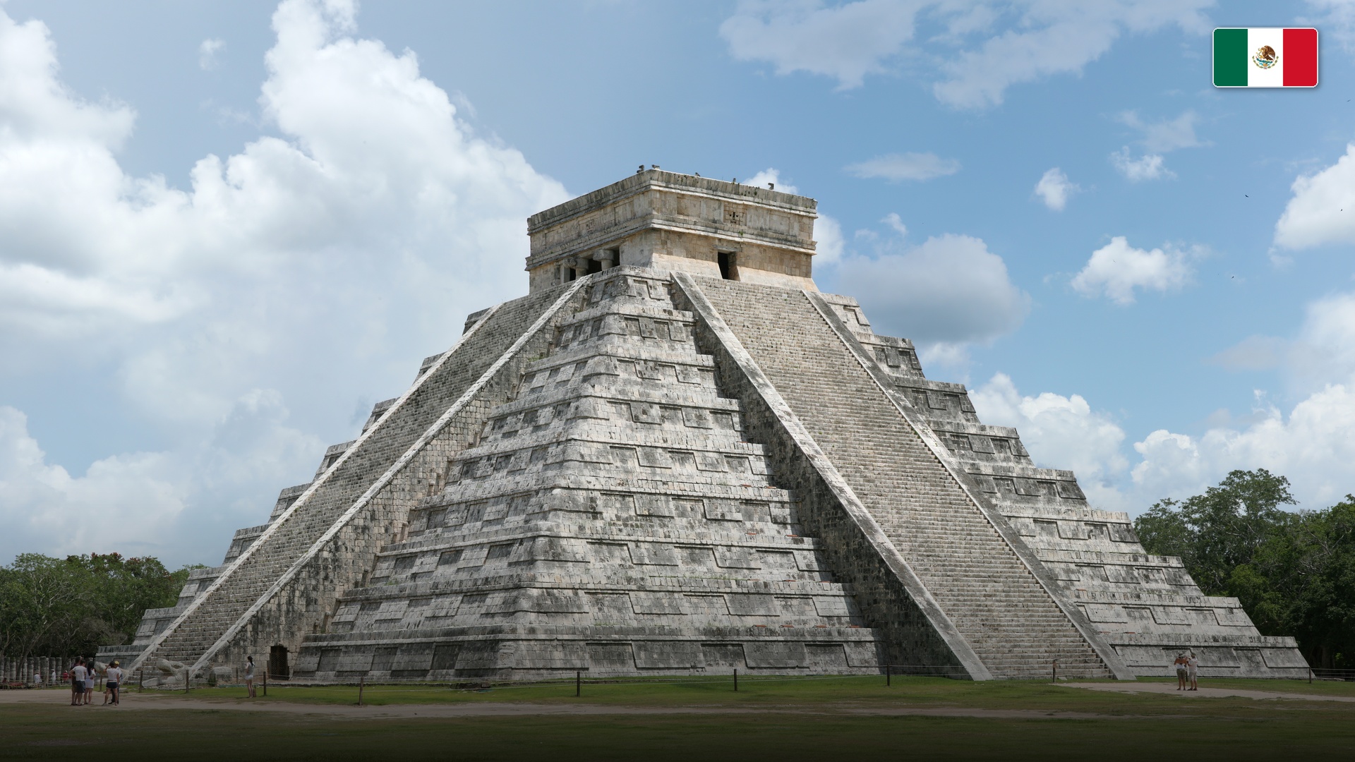 El Castillo pyramid at Chichen Itza under clear skies with lush Yucatan greenery.