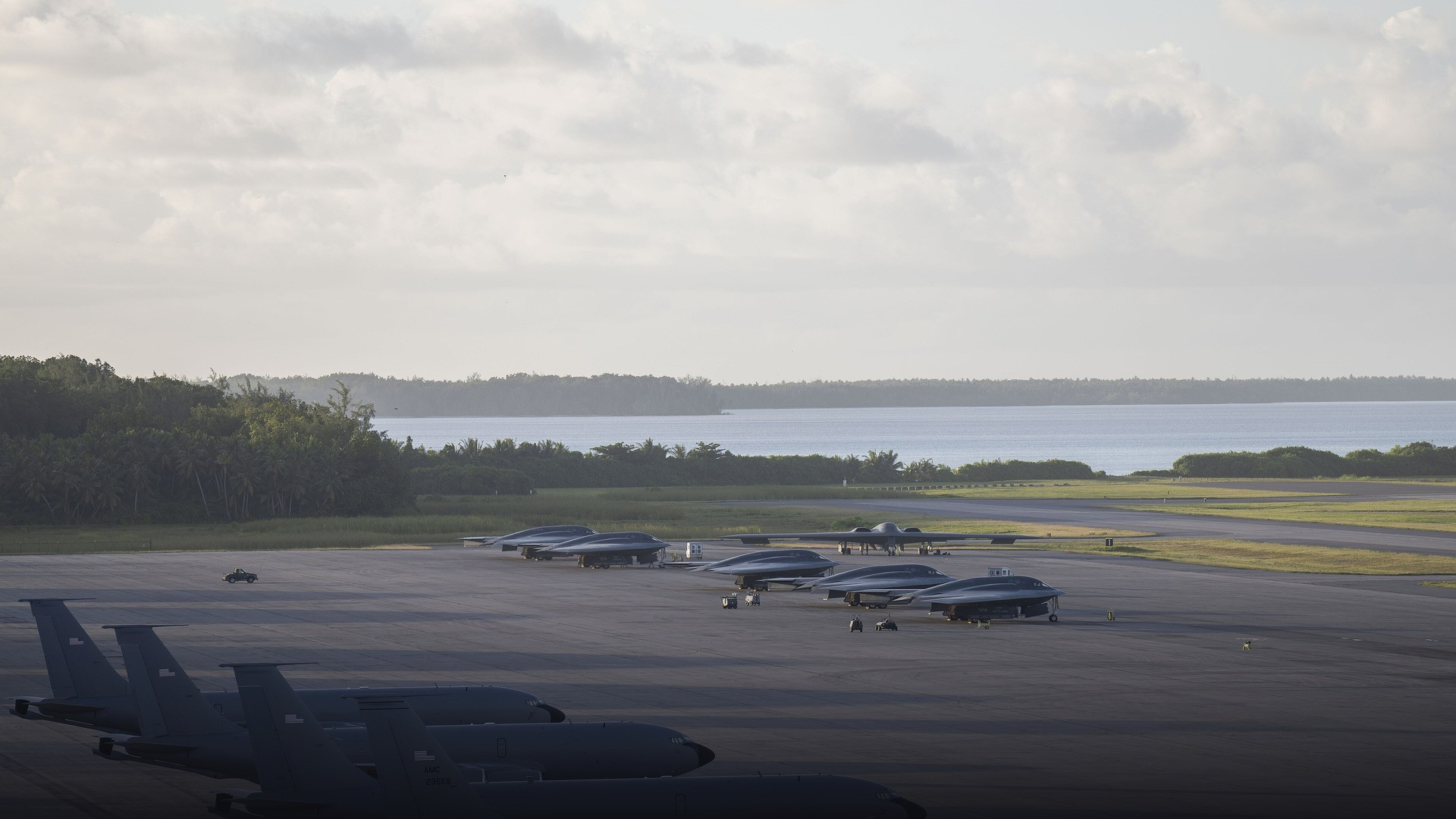 A military transport aircraft on the Diego Garcia flightline with airmen silhouetted against airfield lights.