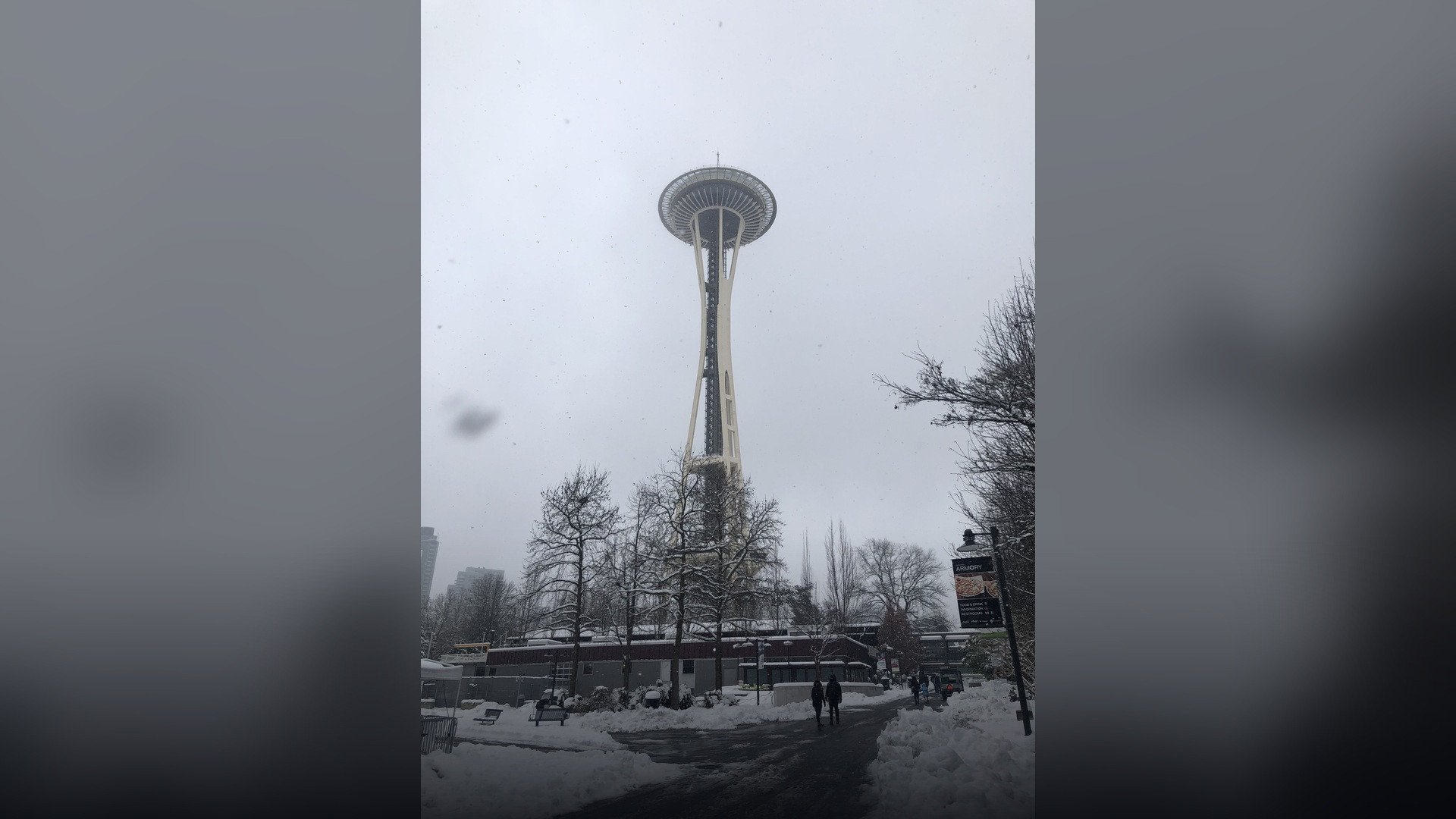 The Space Needle towering high into a gray winter sky amid a Seattle snowstorm.