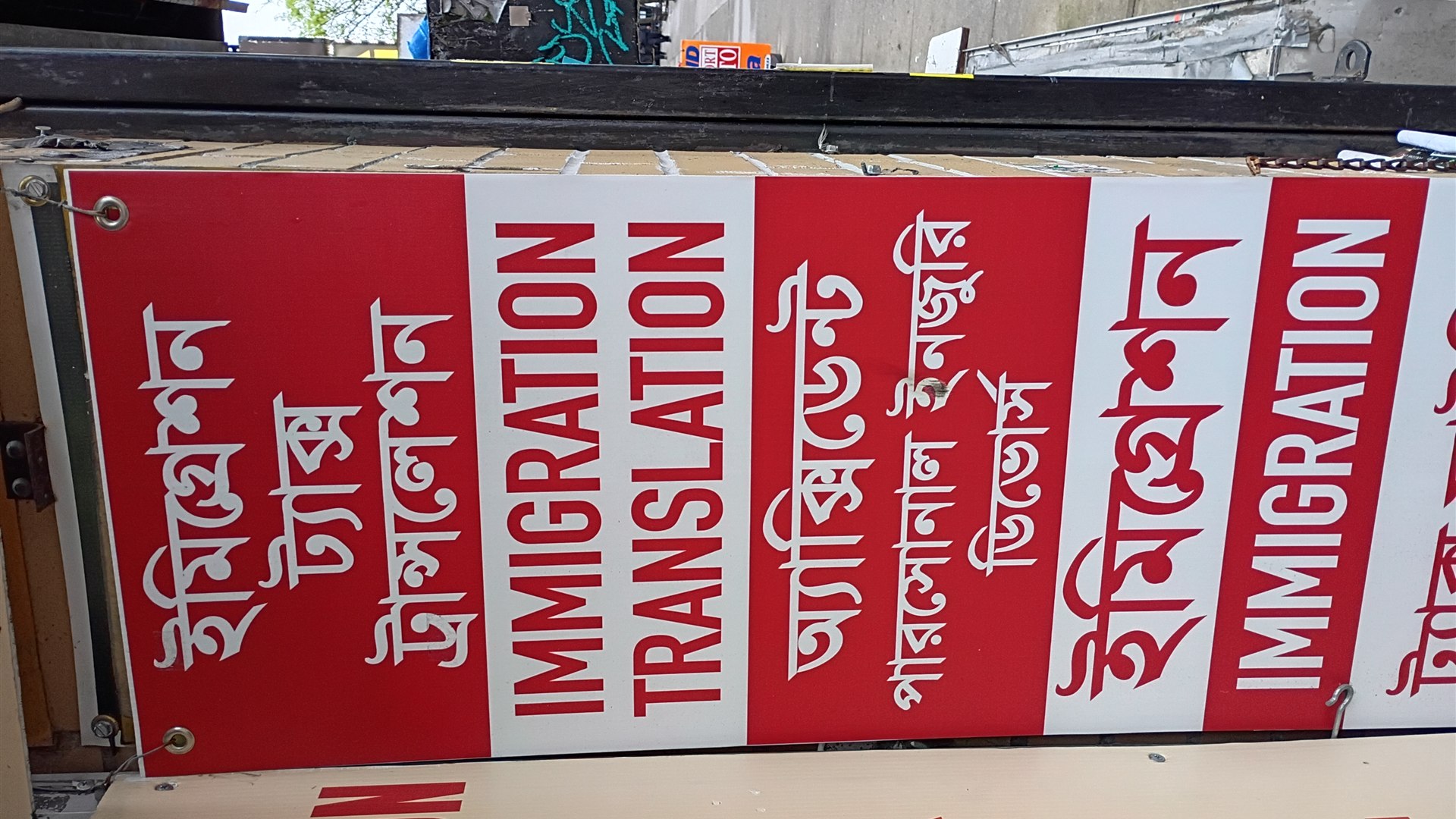 Colourful multilingual street signs in Jackson Heights Queens showing multiple languages