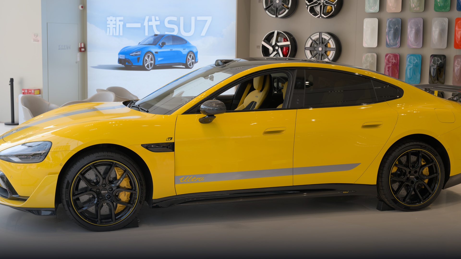 Vibrant yellow Xiaomi SU7 Ultra track hyper-sedan in pristine official showroom lighting.