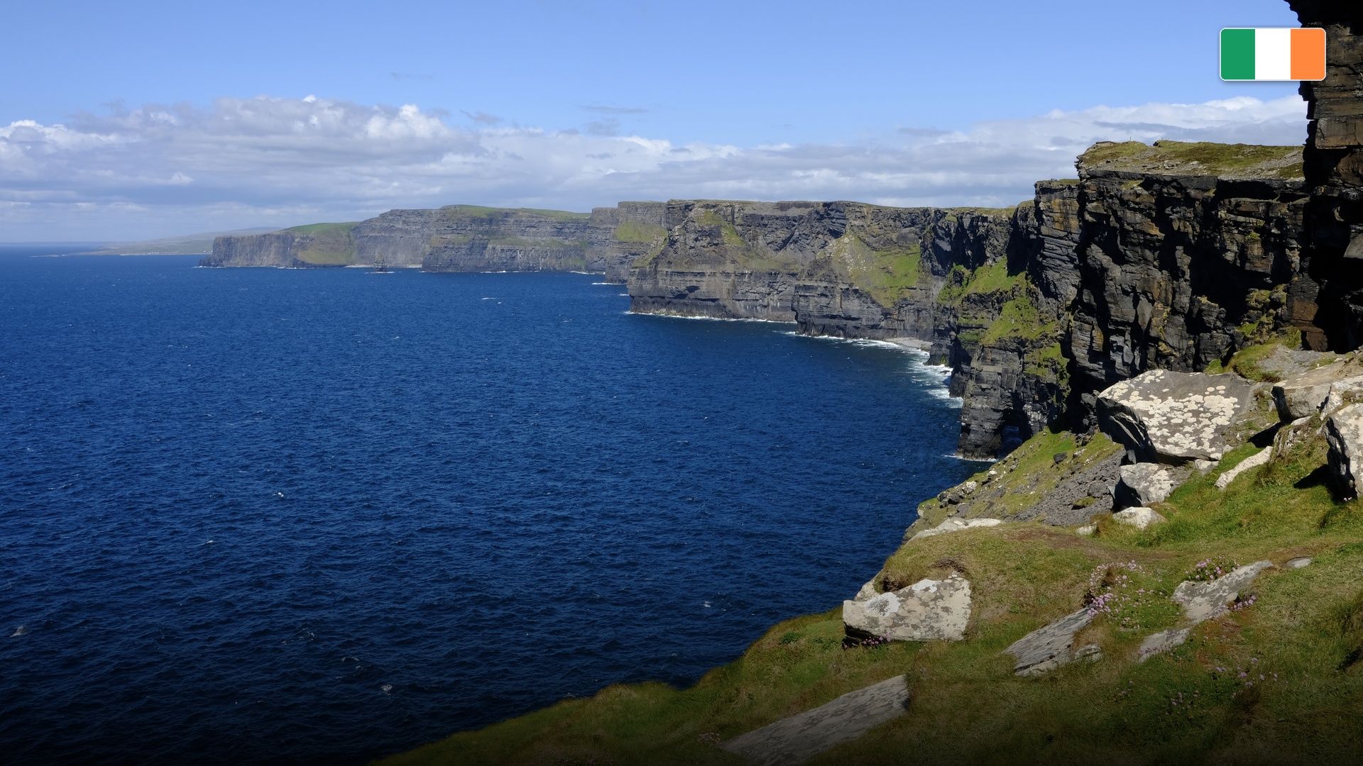 Cliffs of Moher dropping steeply into the crashing Atlantic Ocean on the rugged Irish coast.