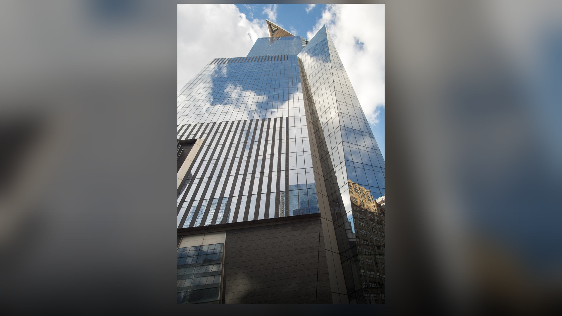 A view of 30 Hudson Yards showcasing its angled glass parapet and the triangular cantilevered Edge sky deck.