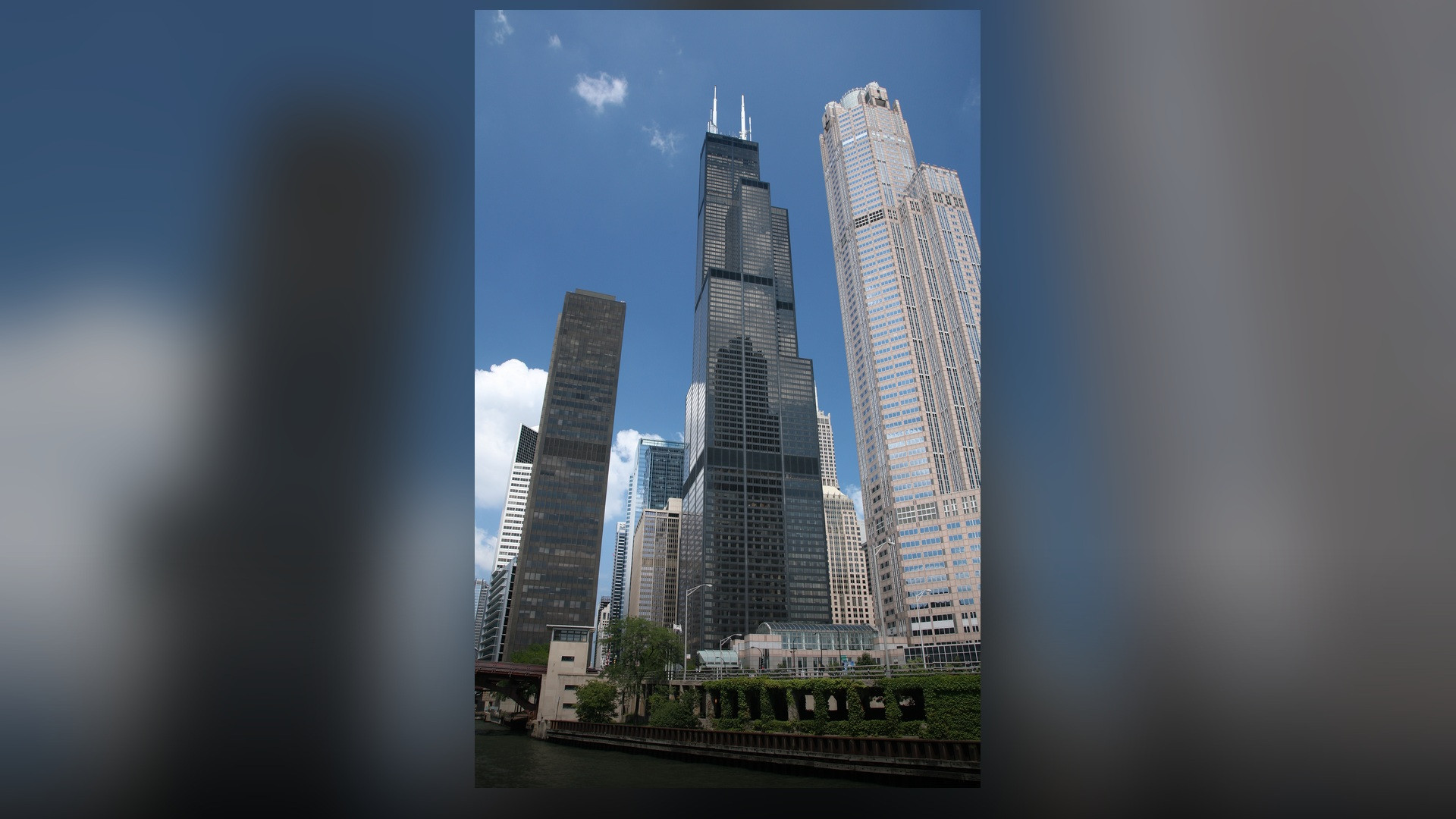 A dramatic low-angle perspective of Willis Tower in Chicago showcasing its bundled black steel tubes.