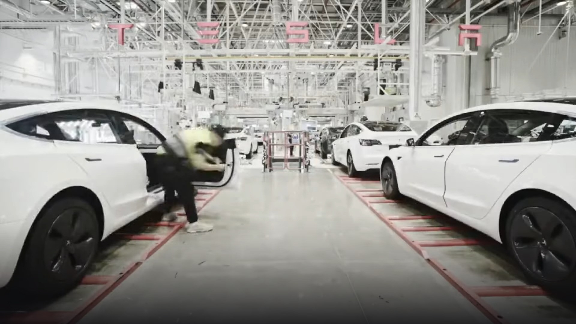 Automated robotic assembly line inside Tesla Gigafactory Shanghai producing electric vehicles.