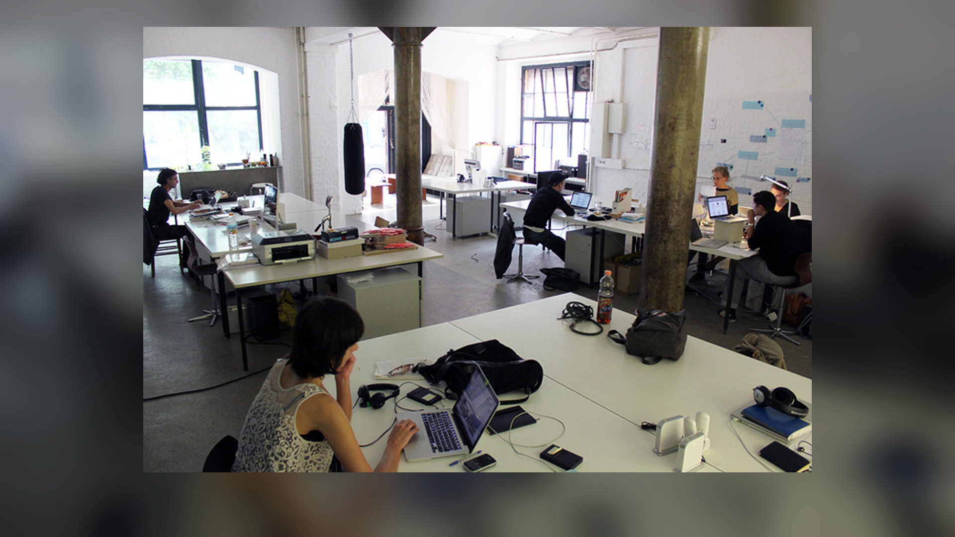 Open plan modern office workspace with desks and collaboration areas.