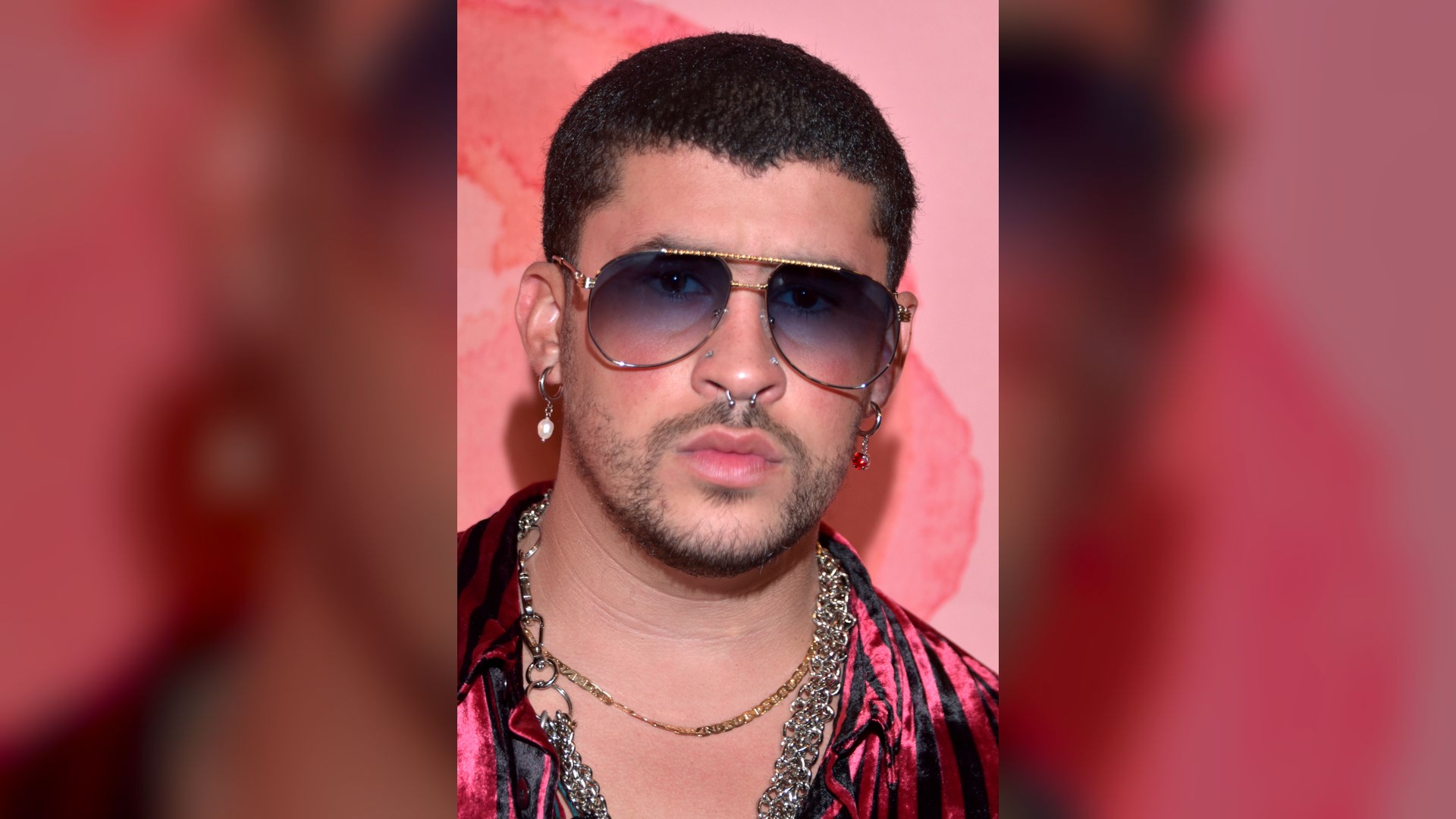 Bad Bunny addressing a massive stadium crowd during an energetic live performance.