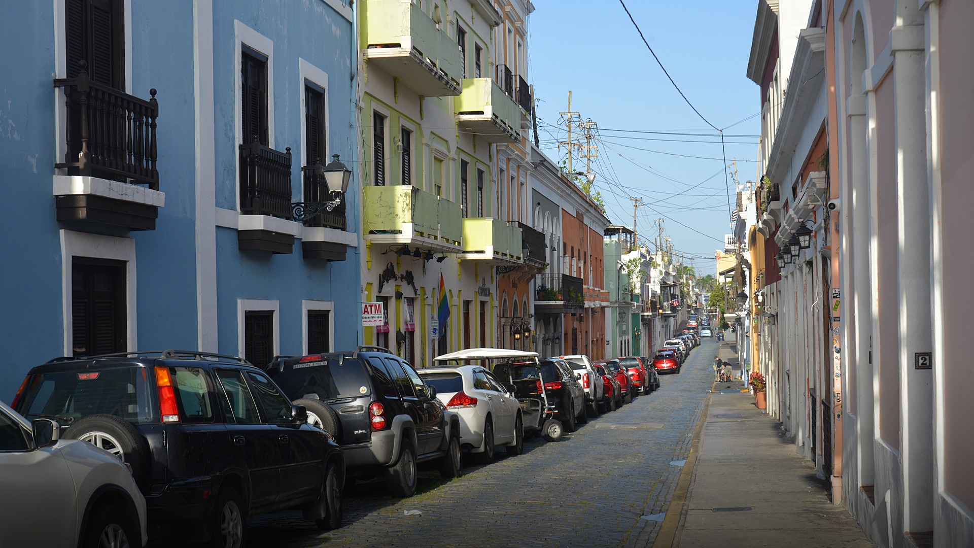 Historic Calle San Sebastian in Old San Juan Puerto Rico lined with colorful Spanish colonial buildings and cobblestone paving.