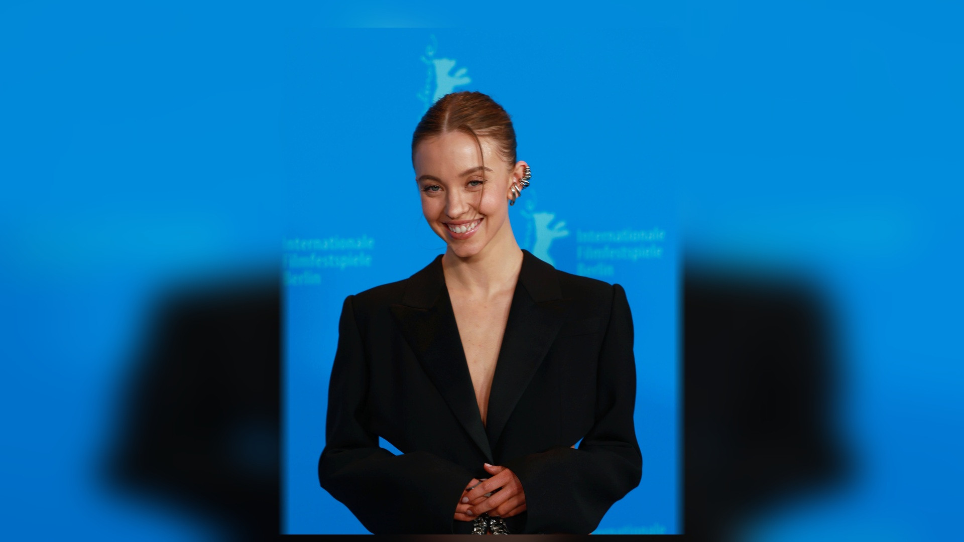Full-length red carpet photograph of Sydney Sweeney in a red sequined gown at the Berlinale Film Festival.