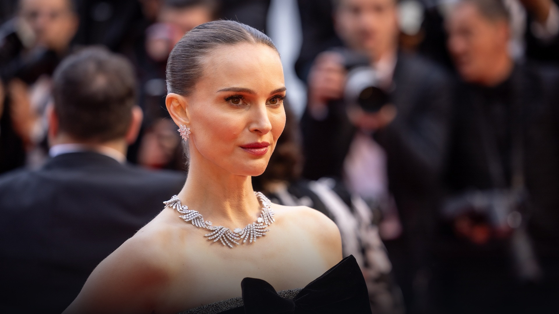 Natalie Portman speaking into a microphone during an international forum panel