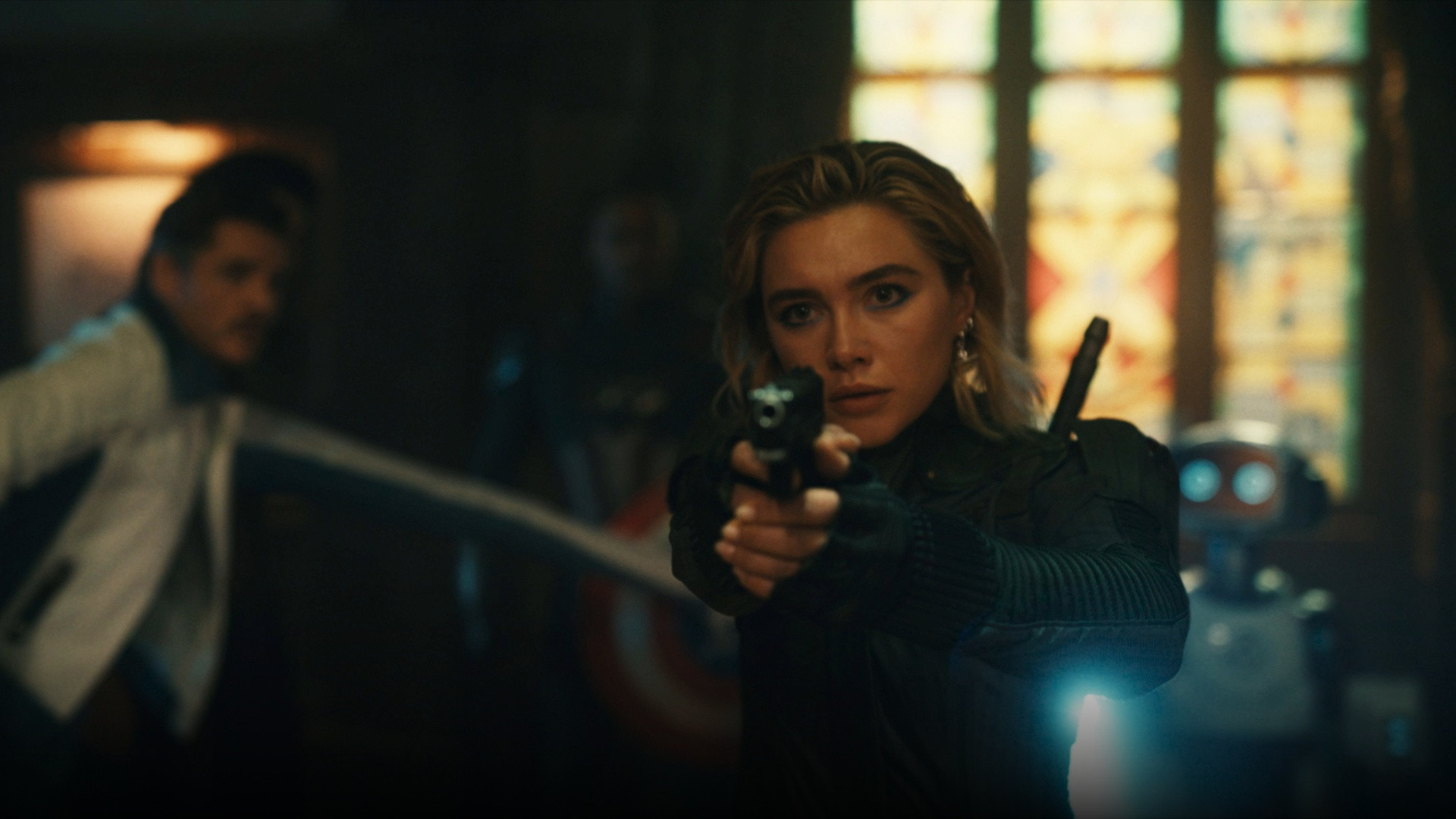 Florence Pugh as Yelena Belova aiming dual pistols in tactical combat gear.