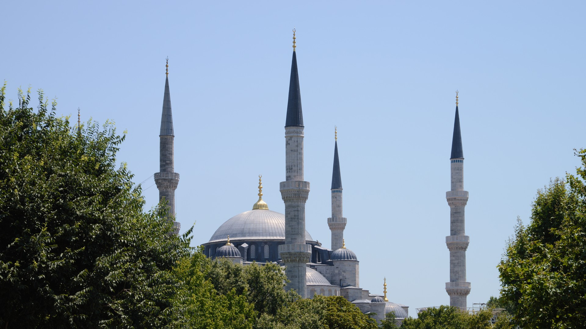 The majestic central dome and towering minarets of Hagia Sophia bathed in sunlight in Istanbul.