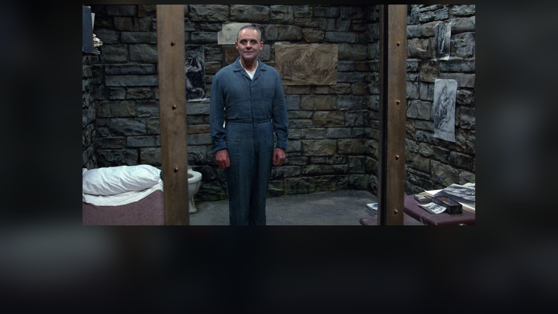 Anthony Hopkins as Dr. Hannibal Lecter behind cell glass in The Silence of the Lambs.