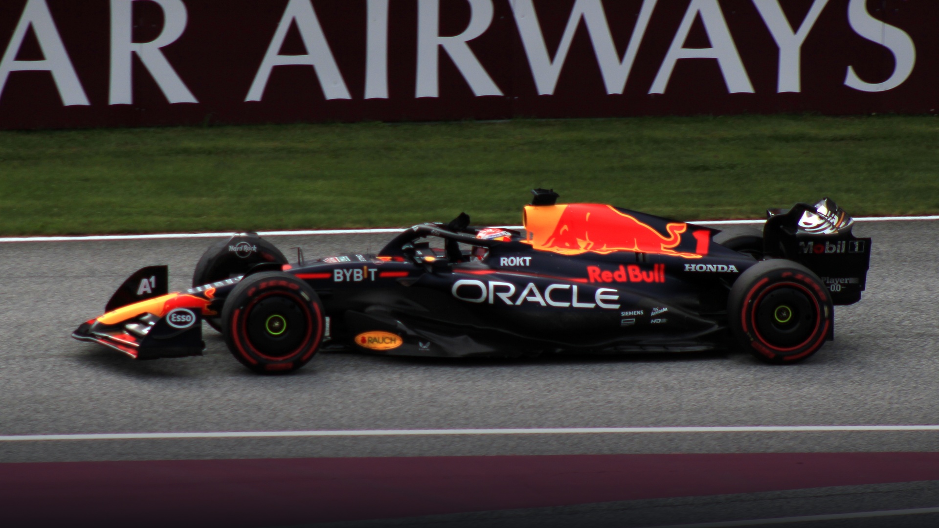 Max Verstappen raising his arm in victory from the cockpit of his Red Bull car on his celebration in-lap.
