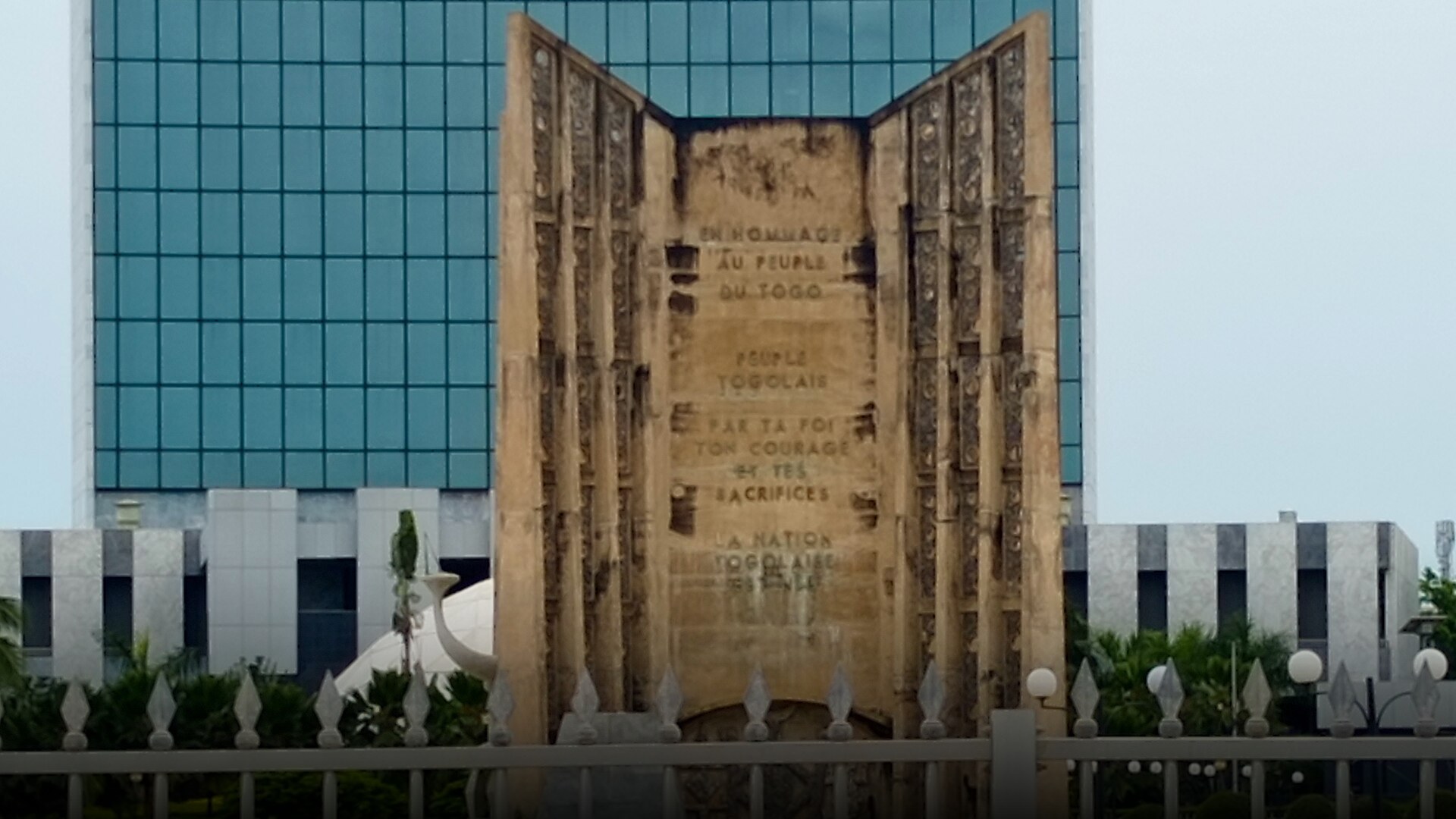 The grand Monument de l'Independence standing tall in a paved central plaza in Lomé, Togo.