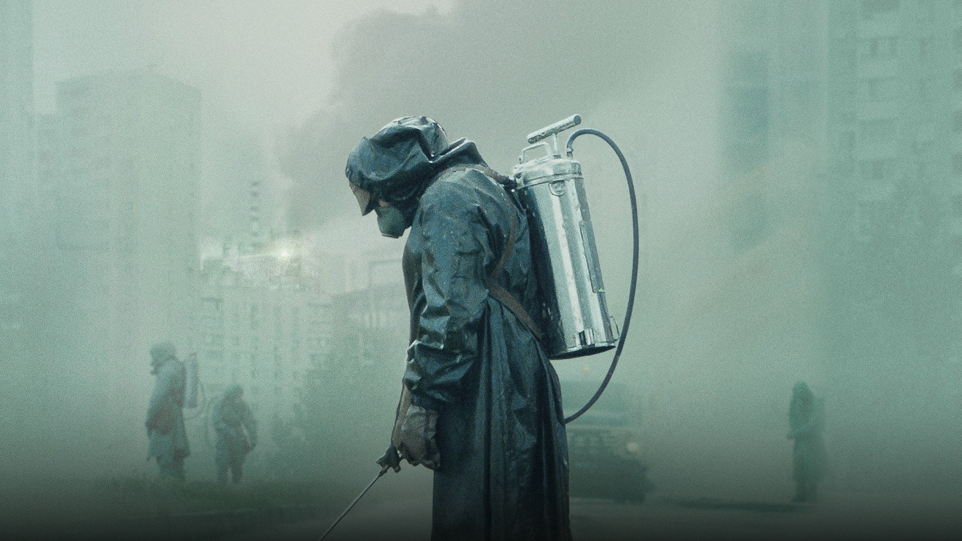 Nuclear plant liquidator in protective suit with decontamination spray in Chernobyl