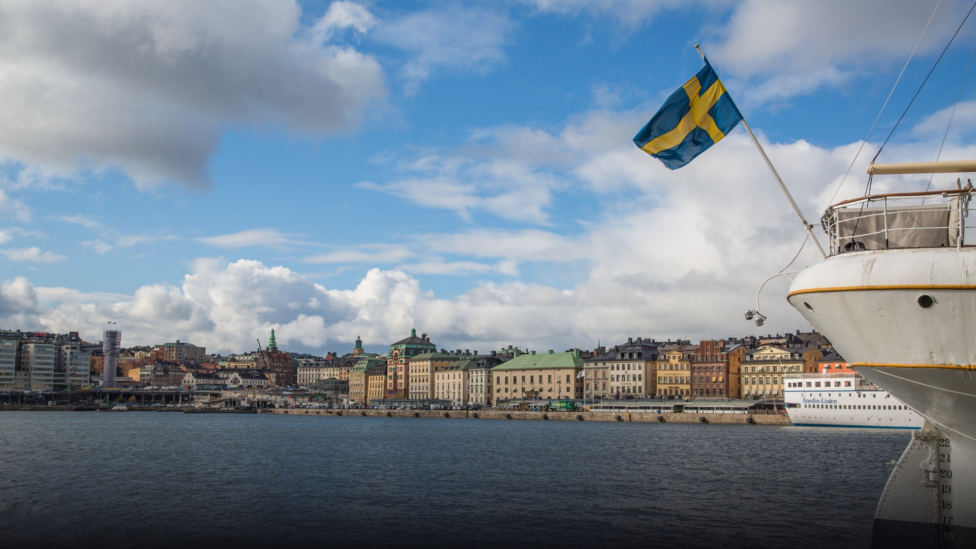 Stockholm waterfront skyline with historical buildings reflecting in the calm waters.