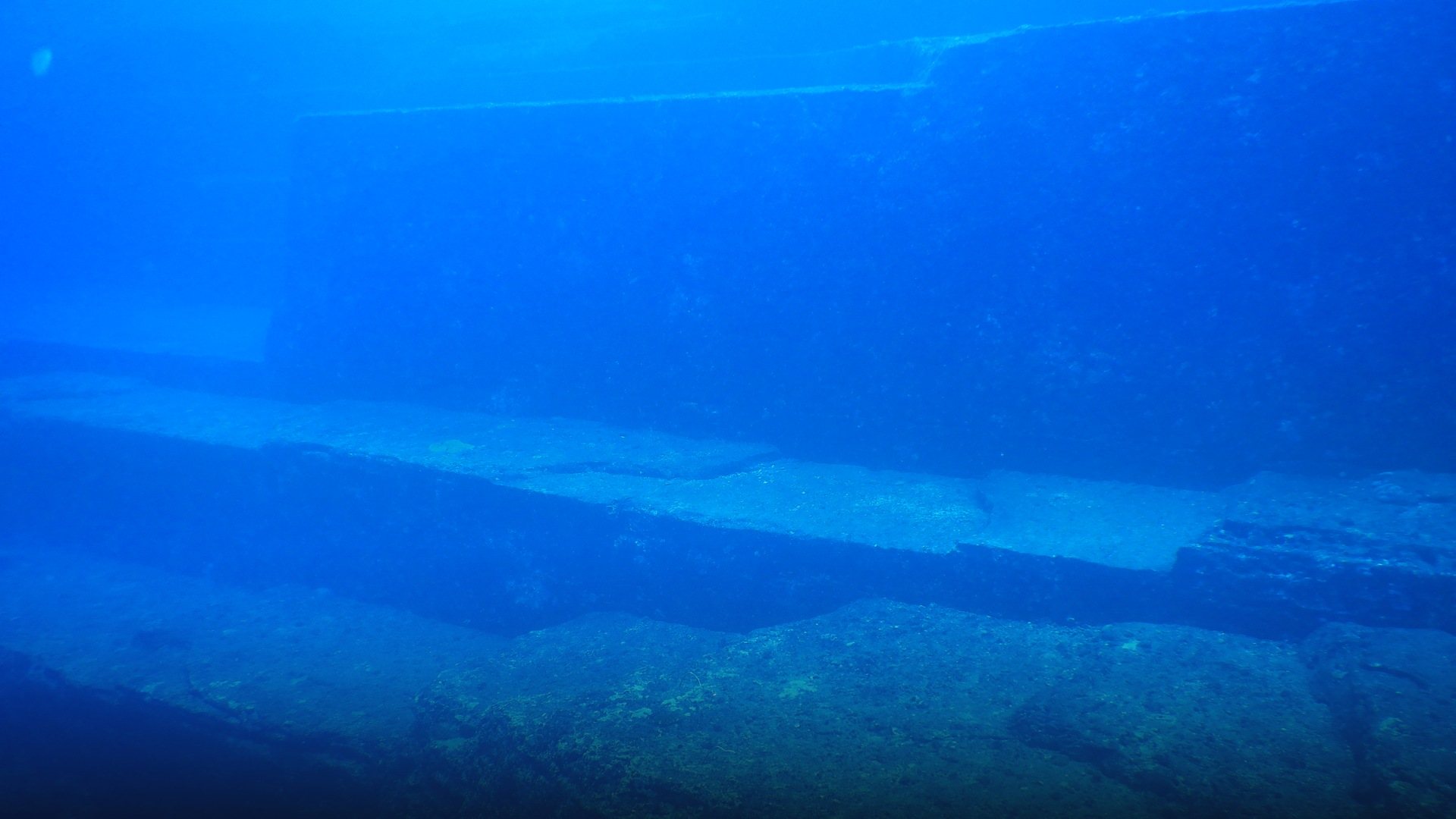 Underwater view of the massive geometric stone terraces and carved steps of the Yonaguni Monument.