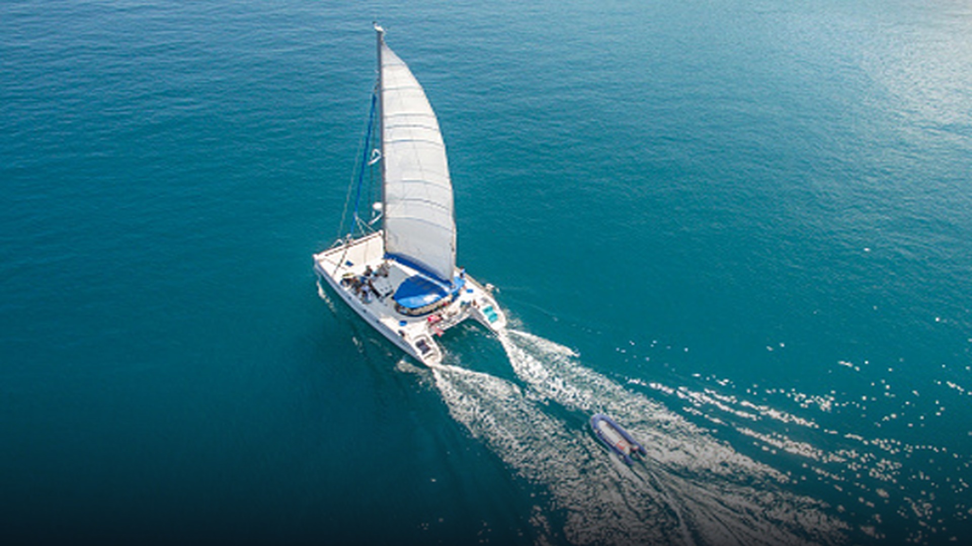 Aerial surveillance photograph of the white catamaran Kaz II drifting silently in open ocean waters.