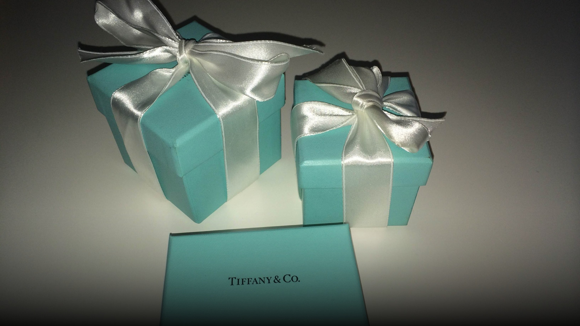 Classic Tiffany and Co. robin egg blue jewelry gift boxes tied with white satin ribbons.