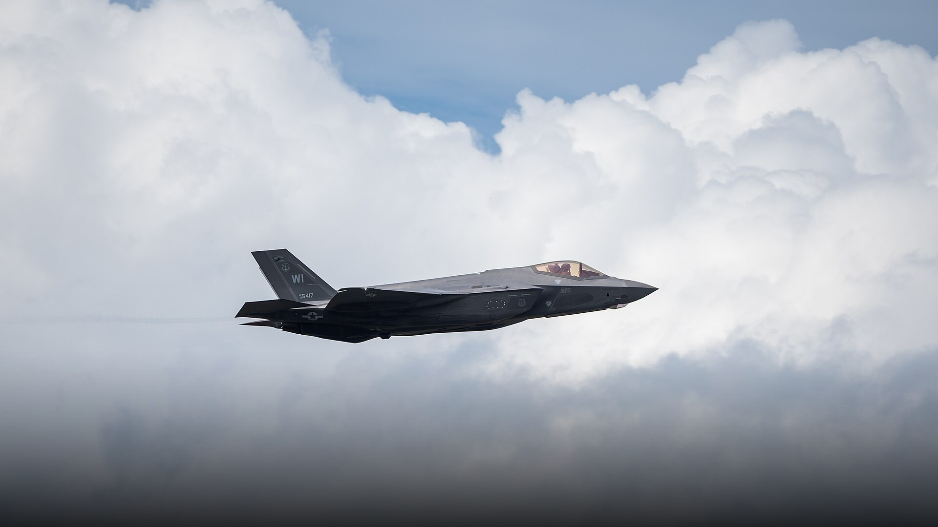 Lockheed Martin F-35A Lightning II stealth multirole fighter jet banking sharply against the sky.