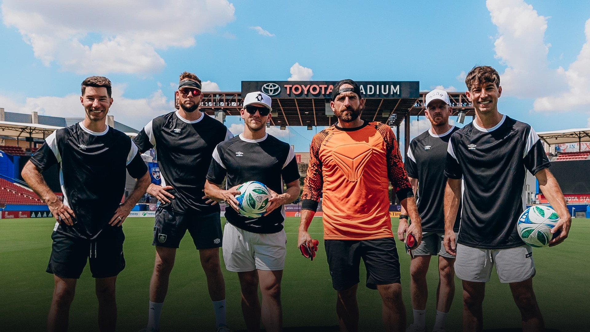The Dude Perfect team standing together on the soccer pitch at Toyota Stadium.