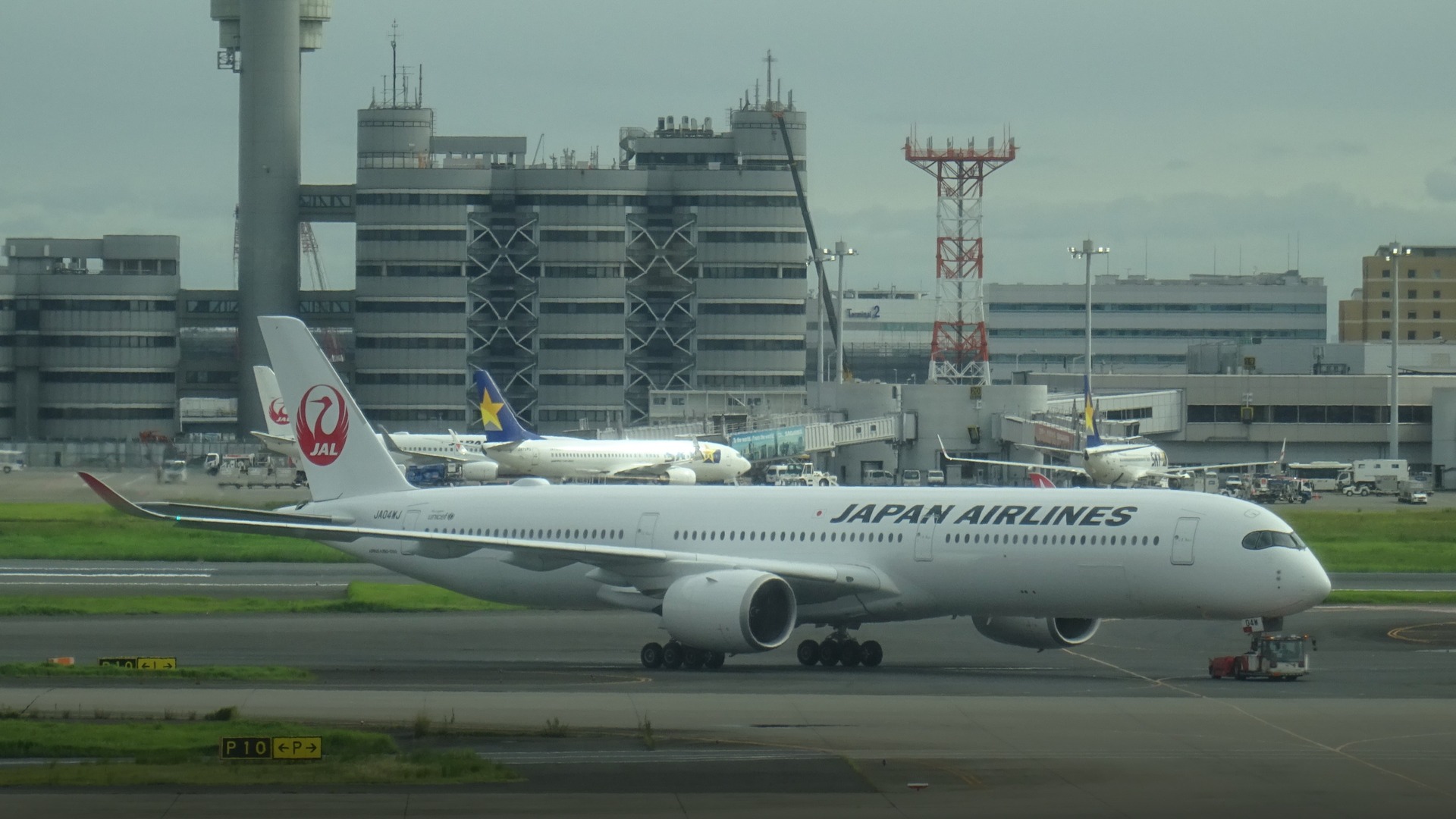 A sleek Japan Airlines Airbus A350-1000 flagship aircraft taxiing gracefully under bright blue skies.