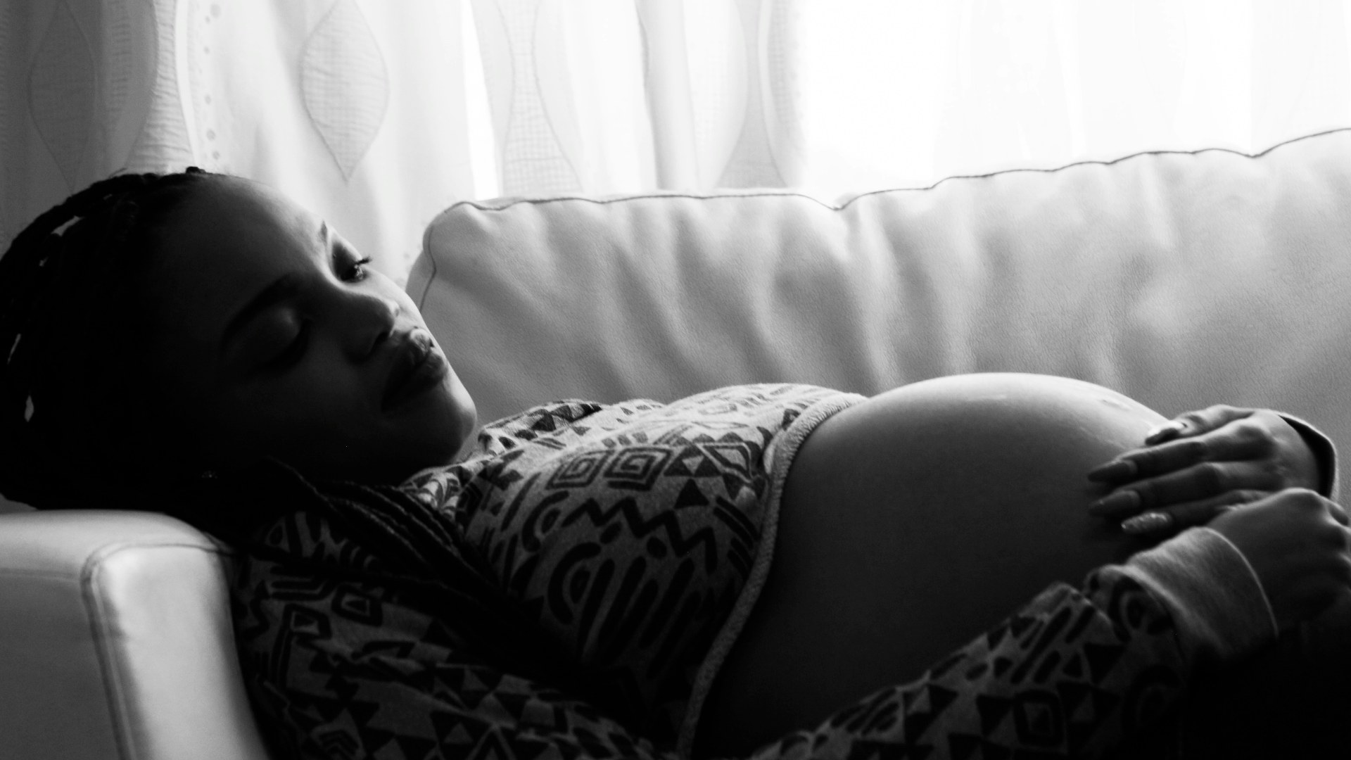 Pregnant woman resting on a sofa with her legs elevated