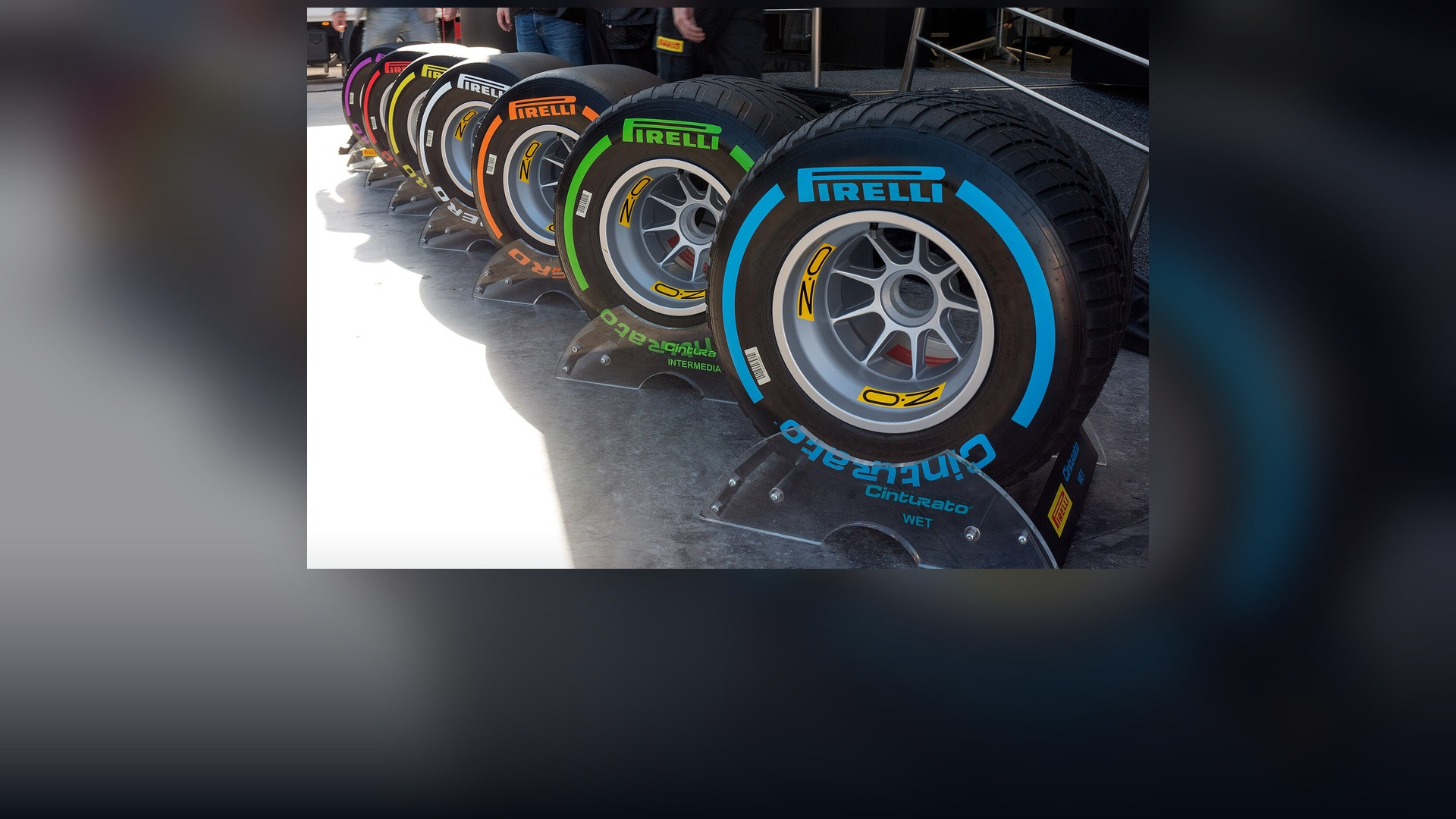 Stacked sets of Pirelli Formula One slick racing tires on tire warmers.