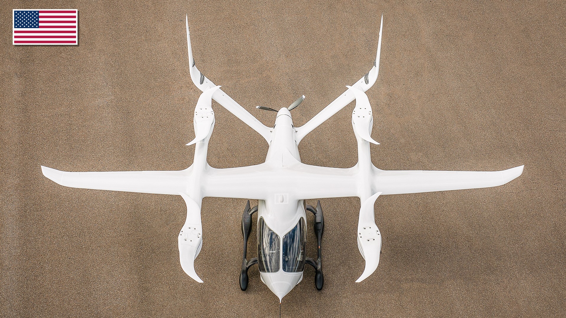 BETA Technologies ALIA-250 electric regional aircraft in flight with the US flag in the top-left corner.