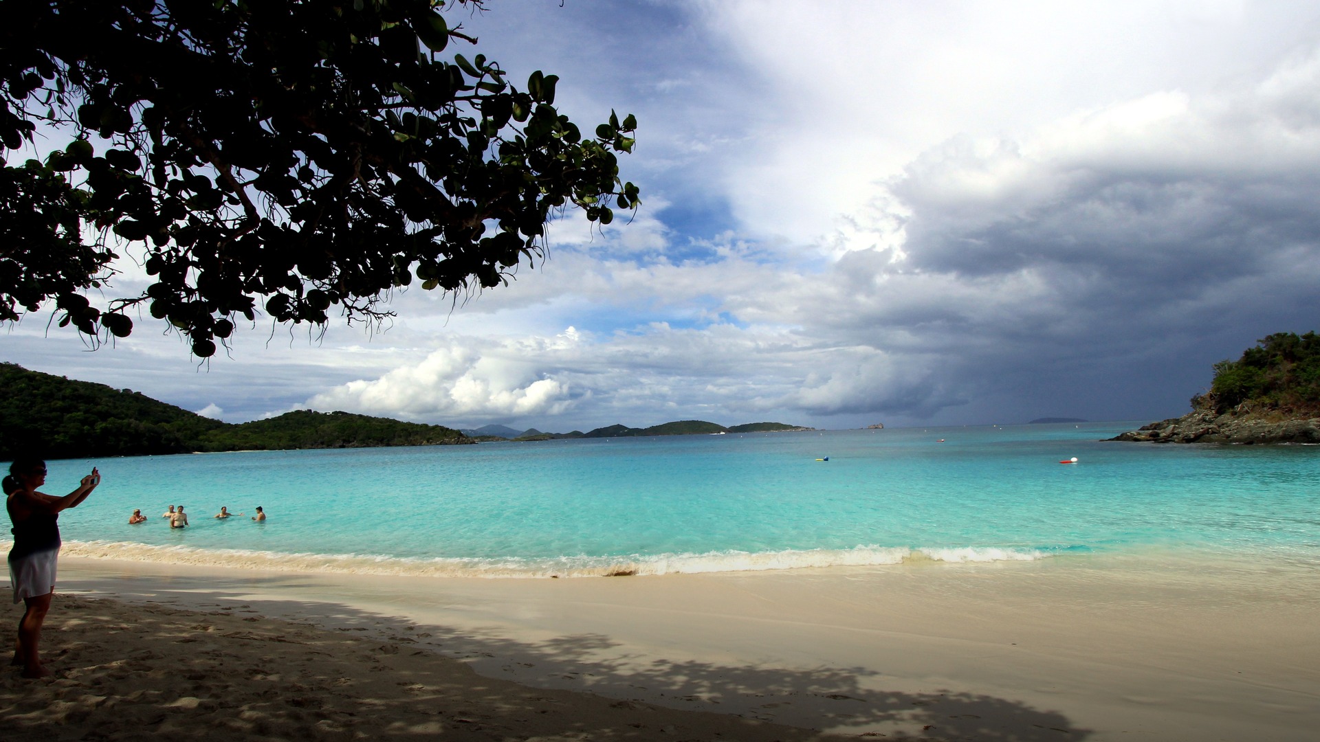 Trunk Bay on St. John in the U.S. Virgin Islands with crystal clear turquoise Caribbean waters and lush green hills.