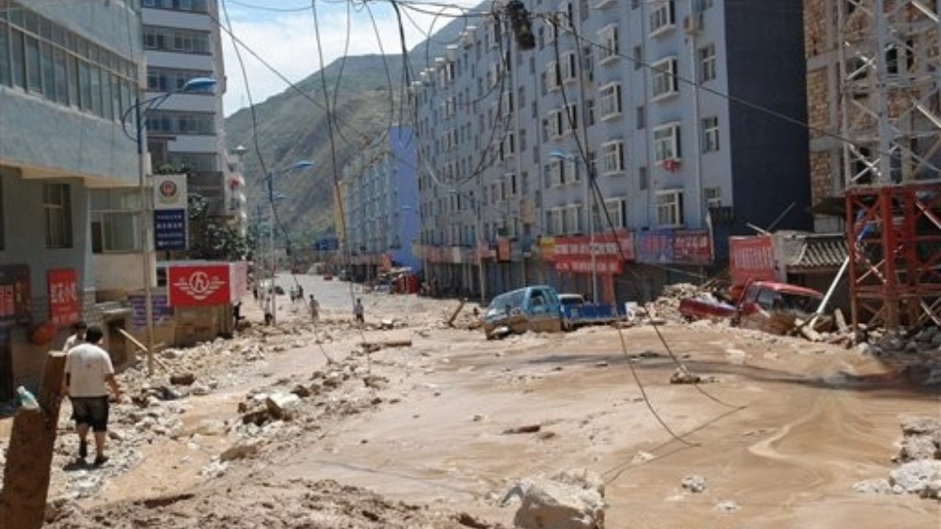 Destroyed and tilted multi-story apartment buildings buried in mud and rubble after the 2010 Gansu mudslide in Zhouqu County, China.